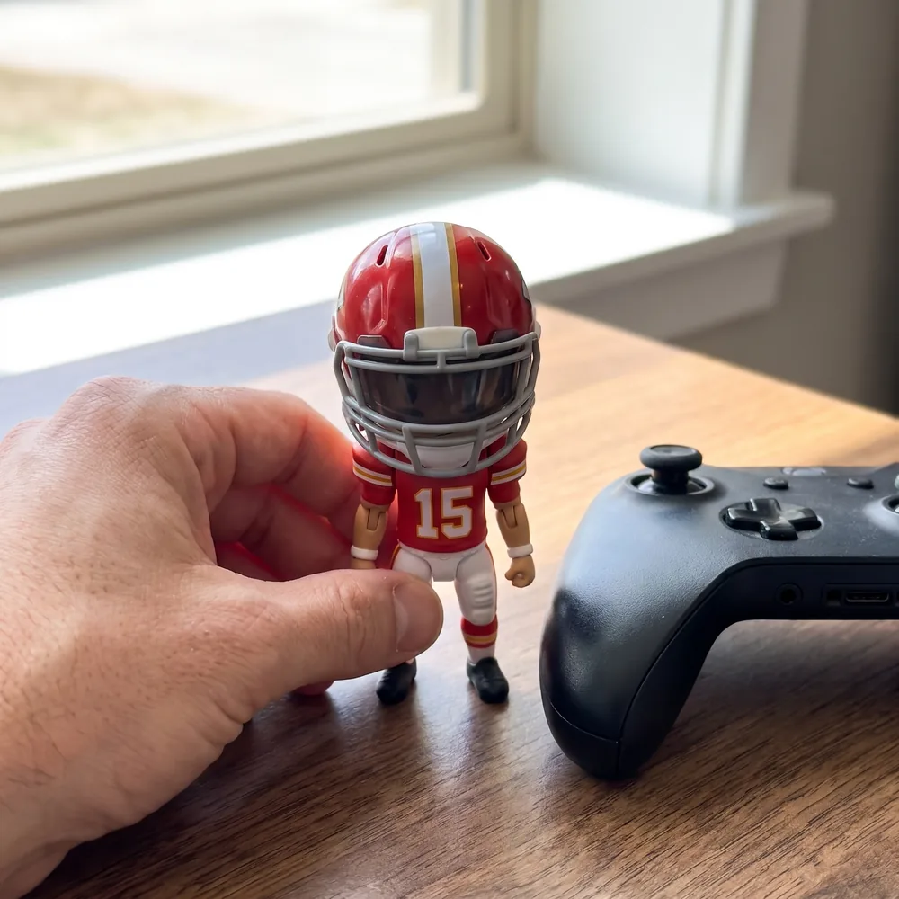 Mini football figure next to a game controller